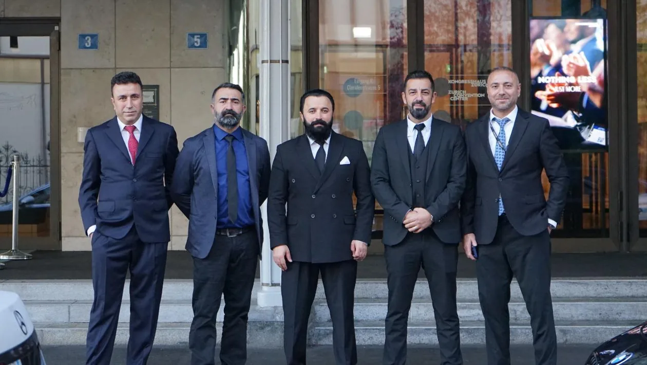 Five Swiss Transfer Service team members in dark suits outside the Kongresshaus Zürich